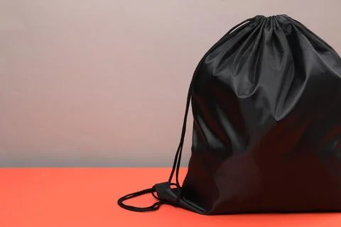 One black drawstring bag on grey background, closeup. Space for text Foto stock