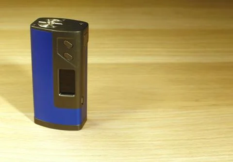 One blue boxmod device for vaping (electronic cigarette) on the wooden surf.. Stock Photos