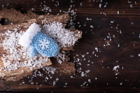 One blue mitten with a snowflake on the bark and a dark wooden table in the s Foto stock