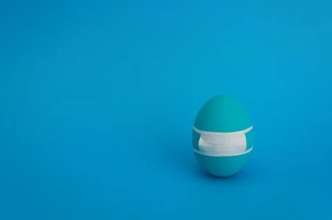 One blue painted easter egg in handmade medicine mask. Easter concept. Stock Photos