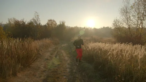 One bold young man running on dirt road holding a map in hand wearing black long Video stock 167337651