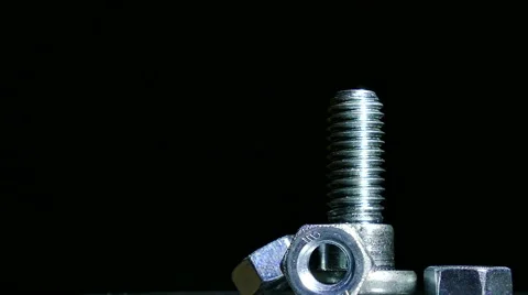 One bolt and three nuts rotates against  dark background. 4K shot Видео 61458157