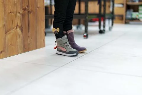 One boot on, one boot off during a shoe try-on at a bright and busy store Stock Photos