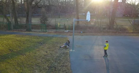 One boy helping another playing basketball Stock Footage 170787430