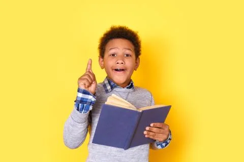One boy student studio isolated on yellow wall pointing up creative idea Stock Photos