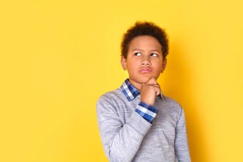 One boy studio isolated on yellow wall thoughtful Stock Photos