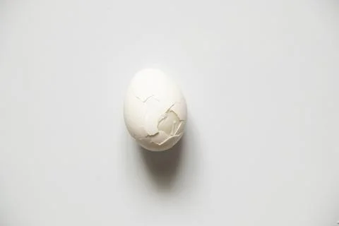 One broken white chicken egg on a white background Stock Photos