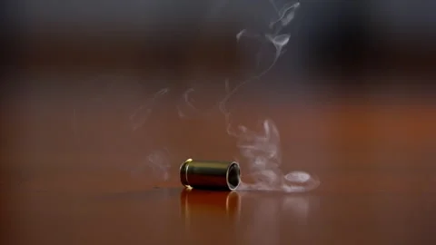 One bullet shell casing falling to wooden surface in slow motion. Fired brass Stock Footage 334021448