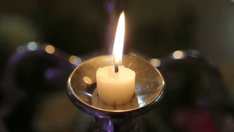 One candle on a table on a black background blazes Stock Footage 80026675