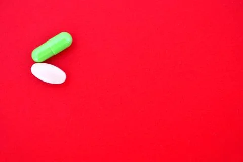 One capsule of green one tablet in white color isolated on a bright background Stock Photos