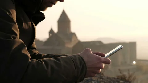 One caucasian young guy use the telephone closeup sitting outside near tradition Stock Footage 201097298