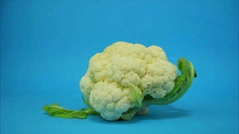 One cauliflower comes in the middle of the frame, spins and leaves the frame Video stock 314342612