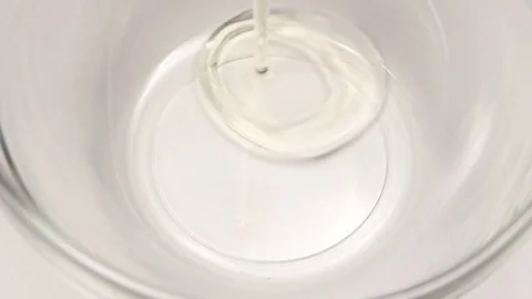 One chicken egg is broken into glass bowl, slow motion Stock Footage 76147111