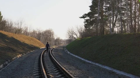 One child boy is walking in the middle of the railway 库存影片 130152080