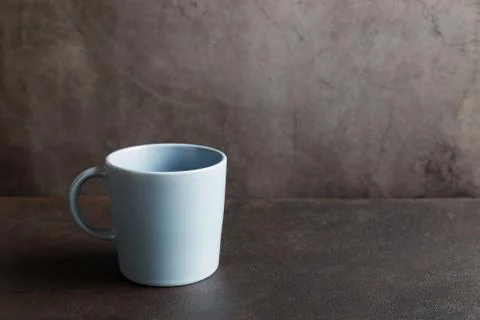 One clean, empty blue cup close up on a dark background with copy space. Stock Photos