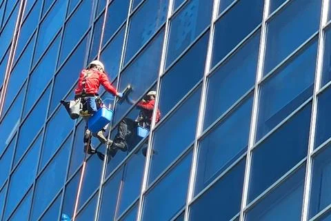 One climber washes the outside windows of a skyscraper at a great height. P.. Stock Photos