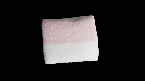 One close-up marshmallow rotates, isolated on a black background Video stock 189323221