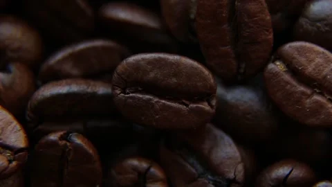 One coffee bean rotates against the background of the other coffee beans. Stock Footage 242490566