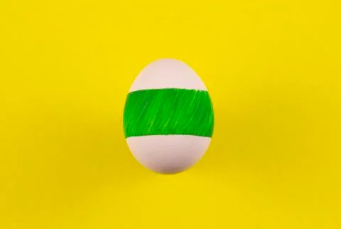 One colored egg on a yellow background. copyspace for text Stock Photos