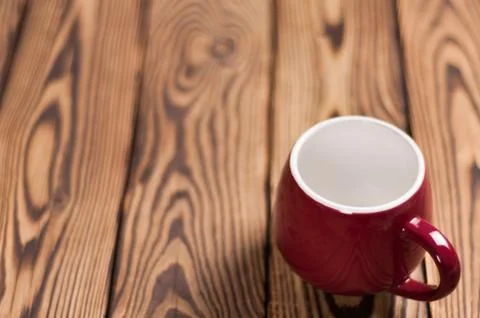One colored empty ceramic clean mug on old worn brown wooden table Stock Photos