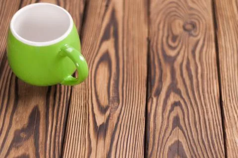 One colored empty ceramic clean mug on old worn brown wooden table Stock Photos
