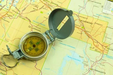 One compass on top of a road map book, space for text. Travel equipment Foto stock