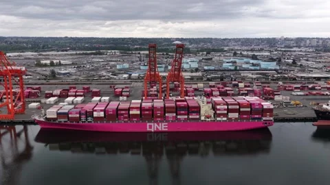 ONE container ship docked at Port of Tacoma with stacked cargo, orange gantry Stock Footage 337451135