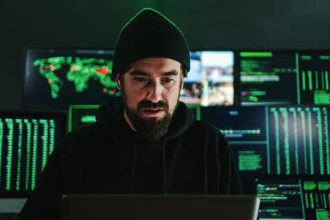 One criminal hacker man programming a phishing virus, at background a lot of Stock Photos