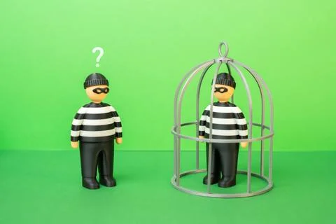 One criminal imprisoned while another remains free. Court practice, legal p.. Stock Photos