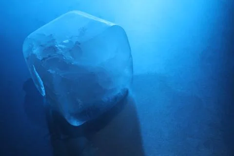 One crystal clear ice cube on light blue background, closeup and space for .. Foto stock