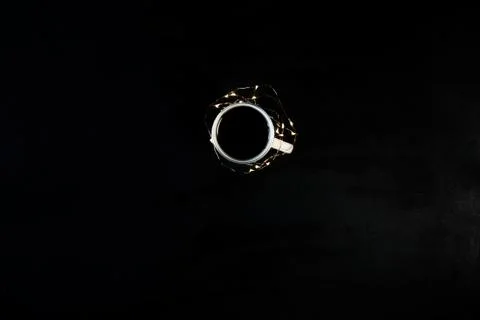 One cup with coffee on black table with christmas lights. Photograph taken fr Stock Photos