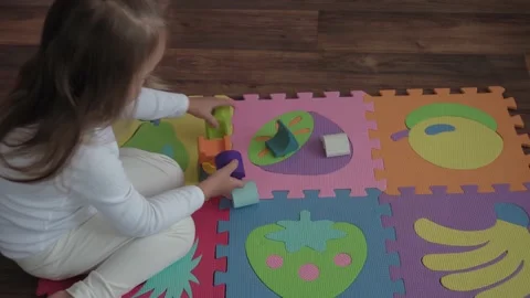 One cute small child build wooden pyramid sitting on colored soft mat puzzle Video stock 142060727