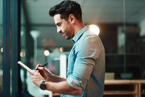 One device, so many supportive functions. Shot of a young businessman using a Stock Photos