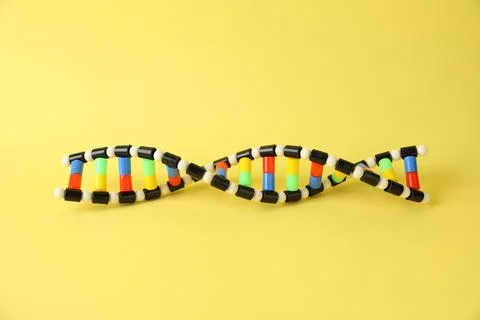 One DNA structure model on yellow background 스톡 사진