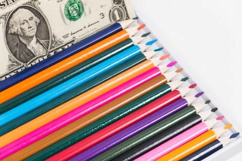 One dollar and a set of colored pencils. Stock Photos