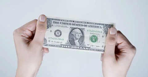 One dollar banknote held between two hands Stock Photos