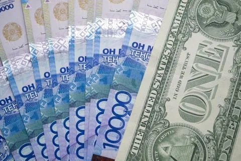 One dollar bill on the background of 10 000 tenge. Stock Photos