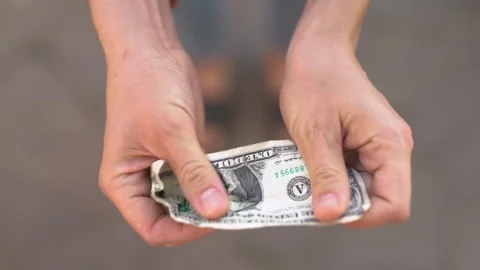A one-dollar bill falls into outstretched palms. Stock Footage 266913440
