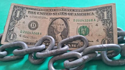 One dollar bill held down by heavy rusted metal chains Stock Photos