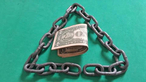 One dollar bill sits inside a triangular heavy metal chain frame Stock Photos