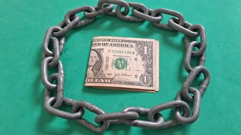 One dollar bill trapped inside a heavy metal circular chain Stock Photos