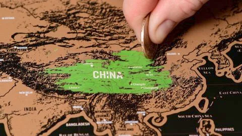 One dollar coin on black scratch travel map of China, Beijing Stock Photos