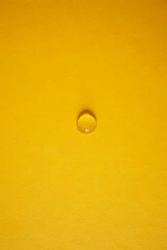 One drop on yellow background Stock Photos