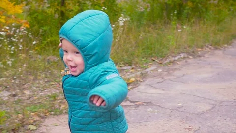 One ear old boy runs in the autumn park and smiles slow motion. gimbal Video stock 80980305