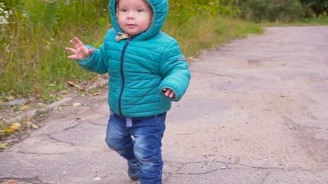 One ear old boy runs in the autumn park and smiles slow motion. gimbal 스톡 동영상 80980857