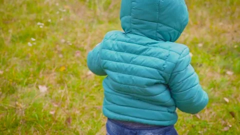 One ear old kid runs through the autumn park and smiles Видео 80970610