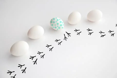One Easter egg among the white eggs, next to the chicken tracks.Easter cocept Stock Photos
