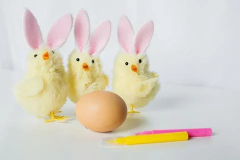 One Easter egg with bright colorful markers and funny small toy chickens wi.. Stock Photos