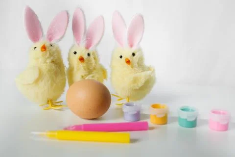 One Easter egg with bright colorful paints, markers and funny small toy chi.. Stock Photos