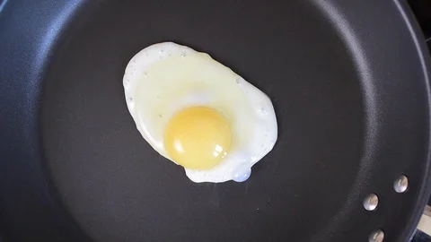 One egg frying on the hot pan, top view Stock Footage 127031905